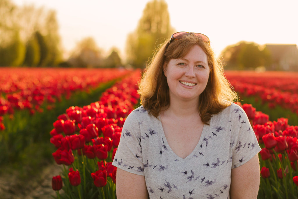 The photographer smiling and in a field of red tulips